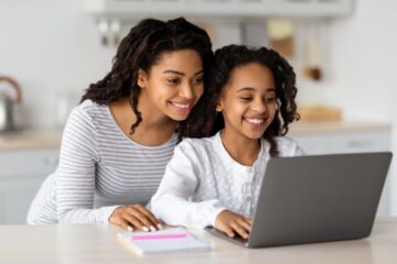A woman looks at a school website with her daughter. Learn tips for improving your website in this article.