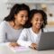 A woman looks at a school website with her daughter. Learn tips for improving your website in this article.