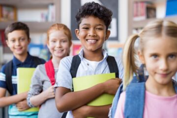 A group of schoolchildren smiling and standing in a line.