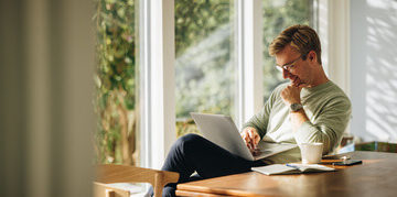 This image shows a man looking at his laptop.