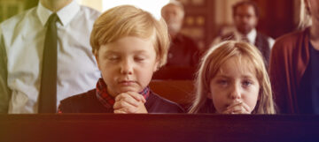 Two children praying in church.